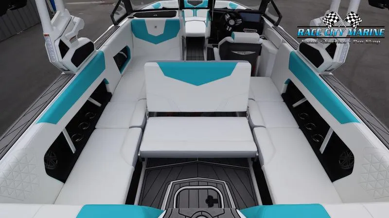 Slide: The Image of 2024 Nautique GS22 boat interior with white and teal seating, Race City Marine logo. - 40