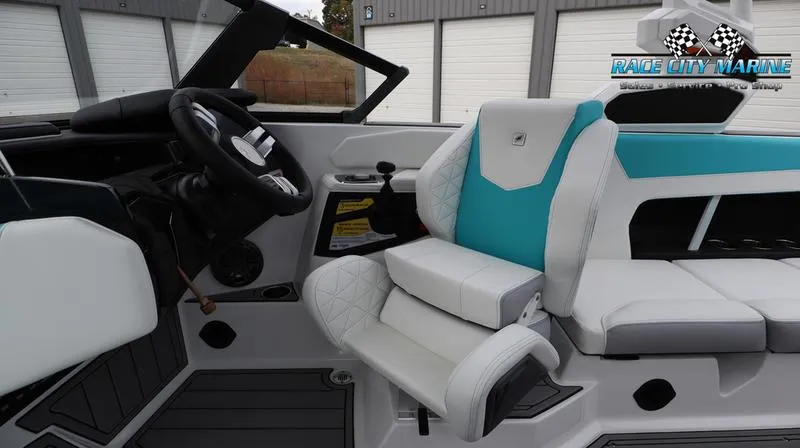 Slide: The Image of 2024 Nautique GS22 boat interior with white and teal seating, Race City Marine logo. - 46