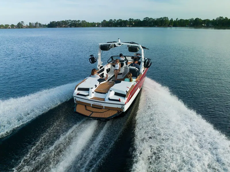Slide: The Image of 2024 Nautique GS22 boat cruising on a lake with passengers. - 6
