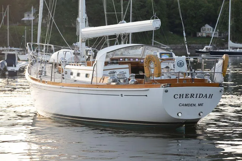 Slide: The Image of Hinckley OceanCruising 52 sailboat from 1997 docked in calm waters, named "Cheridah." - 13