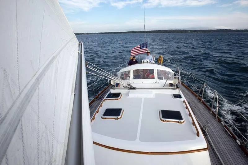 Slide: The Image of Hinckley OceanCruising 52 sailboat from 1997 on open water, American flag flying. - 22