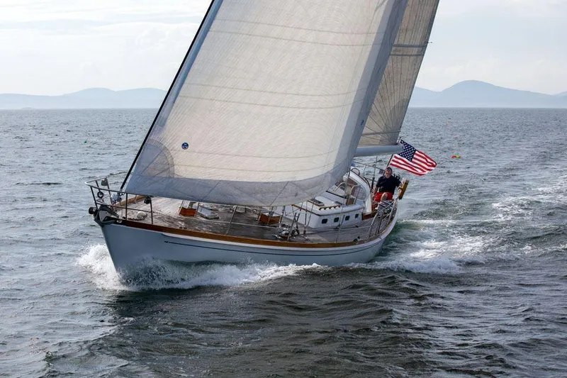 Slide: The Image of Sailing yacht Hinckley OceanCruising 52, 1997 model, gliding on open sea with American flag. - 3