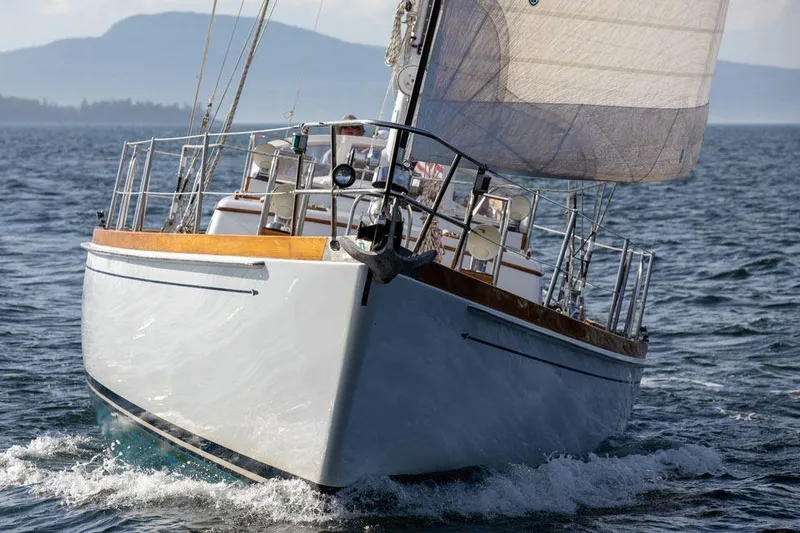 Slide: The Image of Hinckley OceanCruising 52 sailboat from 1997 navigating open waters with mountains in background. - 7