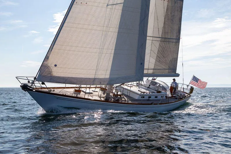 Slide: The Image of Hinckley OceanCruising 52 sailboat from 1997 sailing on open water, American flag flying. - 8