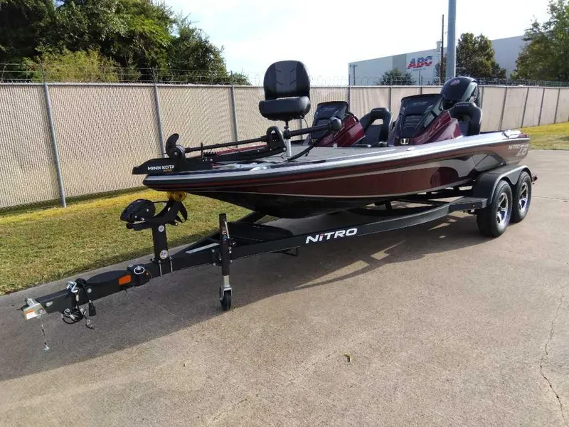 Slide: The Image of 2024 Nitro Z18 fishing boat on a trailer, parked outdoors. - 2