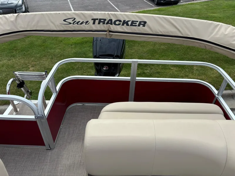 Slide: The Image of 2024 Sun Tracker Party Barge 18 DLX pontoon boat with beige seating and red side panels. - 10