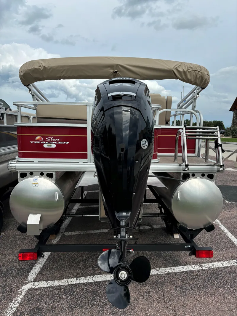 Slide: The Image of 2024 Sun Tracker Party Barge 18 DLX pontoon boat, rear view with outboard motor. - 5