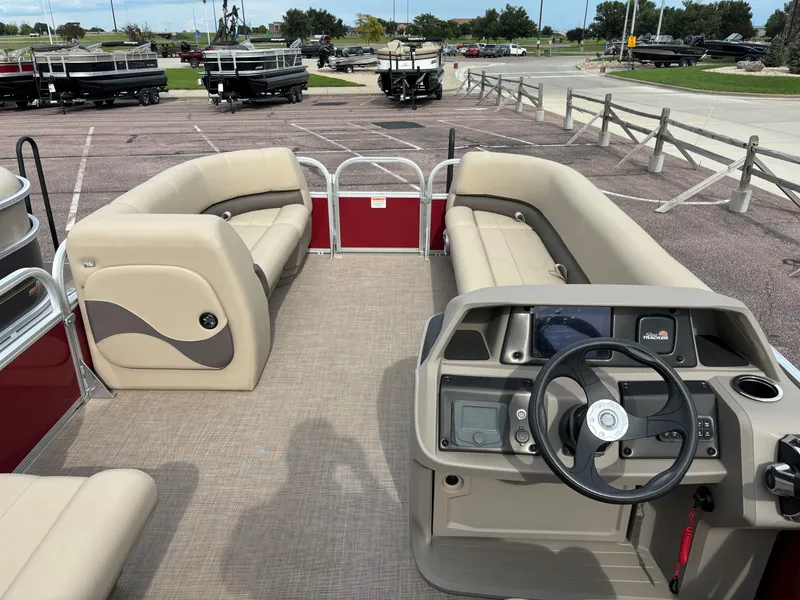 Slide: The Image of 2024 Sun Tracker Party Barge 18 DLX pontoon boat interior with beige seating and steering console. - 6