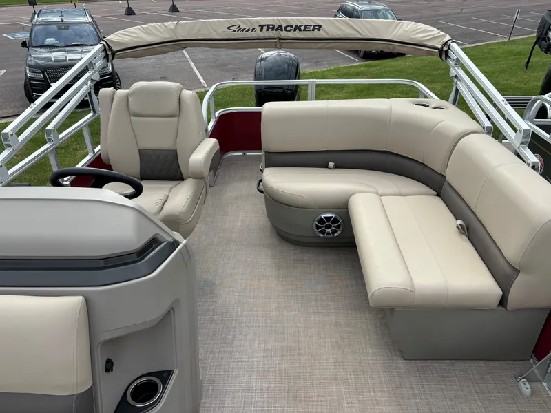 Slide: The Image of 2024 Sun Tracker Party Barge 18 DLX interior with beige seating and steering console. - 8