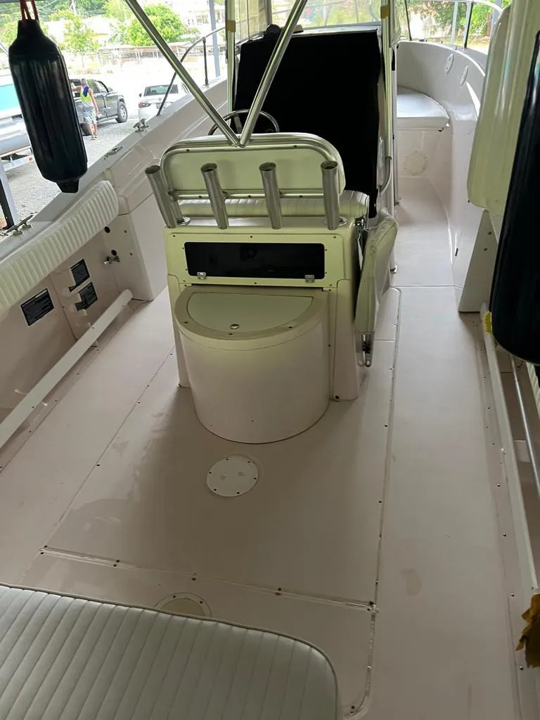 Slide: The Image of 1995 Grady-White Chase 263 boat interior with seating and rod holders. - 2