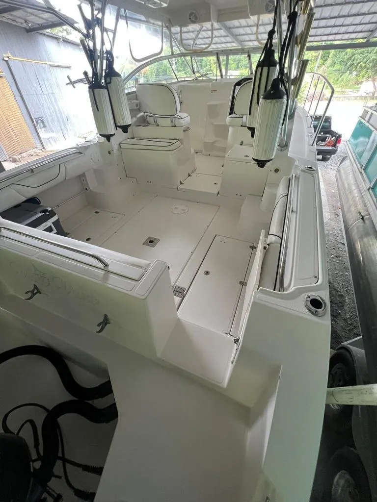 Slide: The Image of 1995 Grady-White Chase 263 boat interior, featuring spacious seating and fishing rod holders. - 4