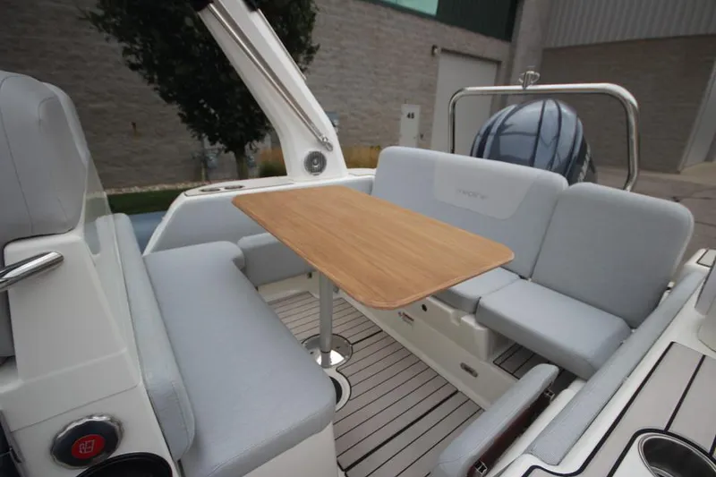Slide: The Image of 2024 Zodiac Medline 7.5 NEO boat interior with seating and wooden table. - 11