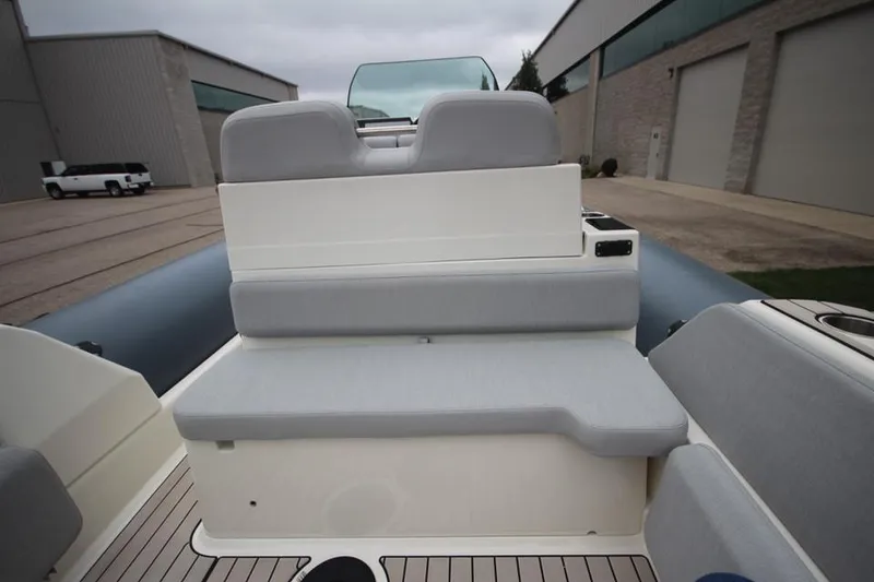 Slide: The Image of 2024 Zodiac Medline 7.5 NEO boat interior with gray seating, docked near industrial buildings. - 15