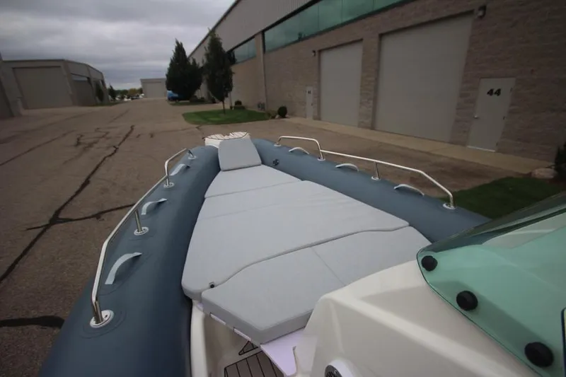 Slide: The Image of 2024 Zodiac Medline 7.5 NEO boat with cushioned deck, parked near industrial buildings. - 24