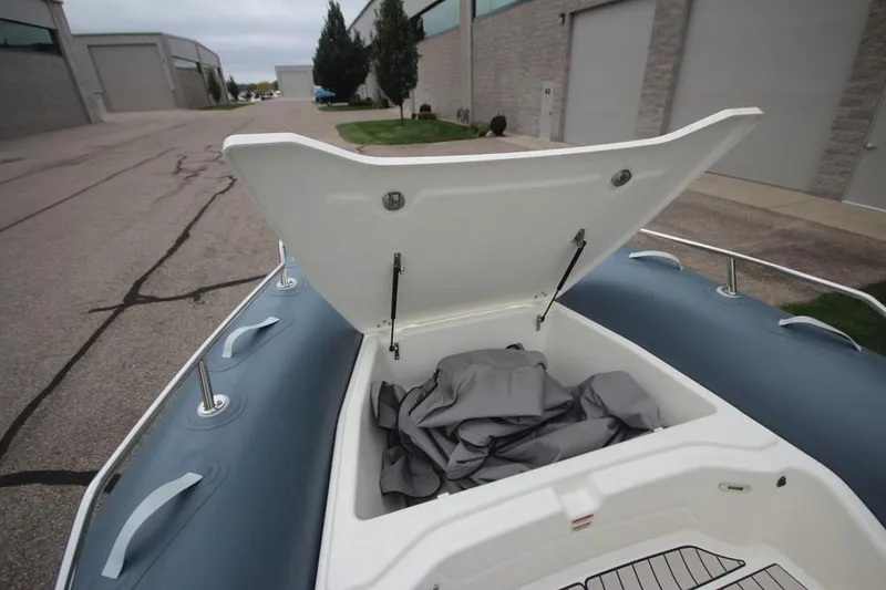 Slide: The Image of 2024 Zodiac Medline 7.5 NEO boat storage compartment open, showing interior space. - 29