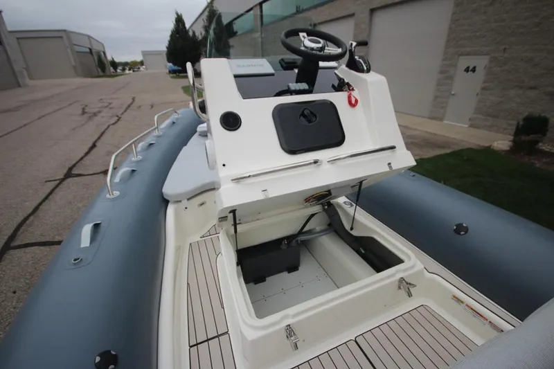 Slide: The Image of 2024 Zodiac Medline 7.5 NEO boat with open storage compartment, docked outdoors. - 32