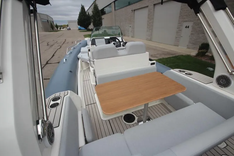 Slide: The Image of 2024 Zodiac Medline 7.5 NEO boat with seating and table, docked outdoors. - 9