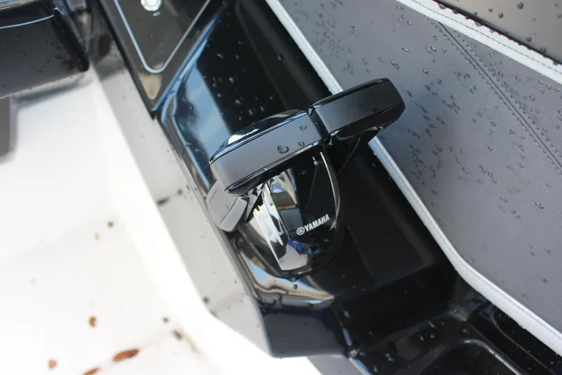 Slide: The Image of Close-up of 2023 Yamaha Boats 252SE cup holder on wet black surface. - 12