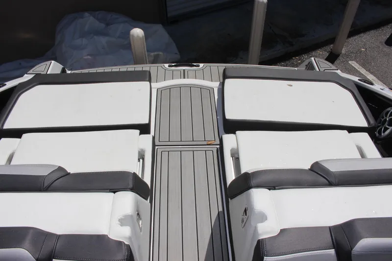 Slide: The Image of 2023 Yamaha Boats 252SE rear deck with cushioned seating and gray flooring. - 15