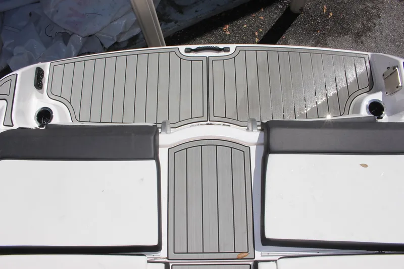 Slide: The Image of 2023 Yamaha Boats 252SE swim platform with gray decking and cushioned seating. - 16