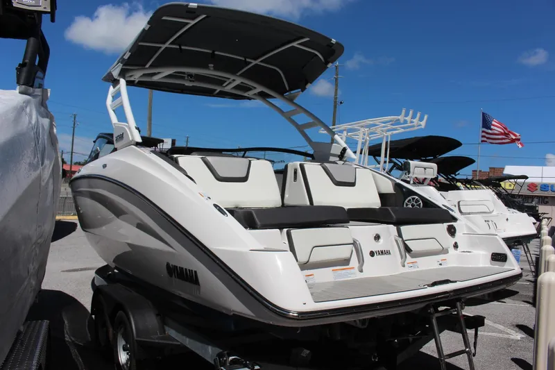 Slide: The Image of 2023 Yamaha Boats 252SE, white, on trailer, rear view with canopy. - 2