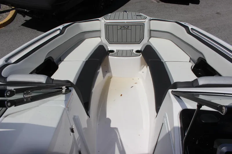 Slide: The Image of 2023 Yamaha Boats 252SE bow seating area with gray and white upholstery. - 5