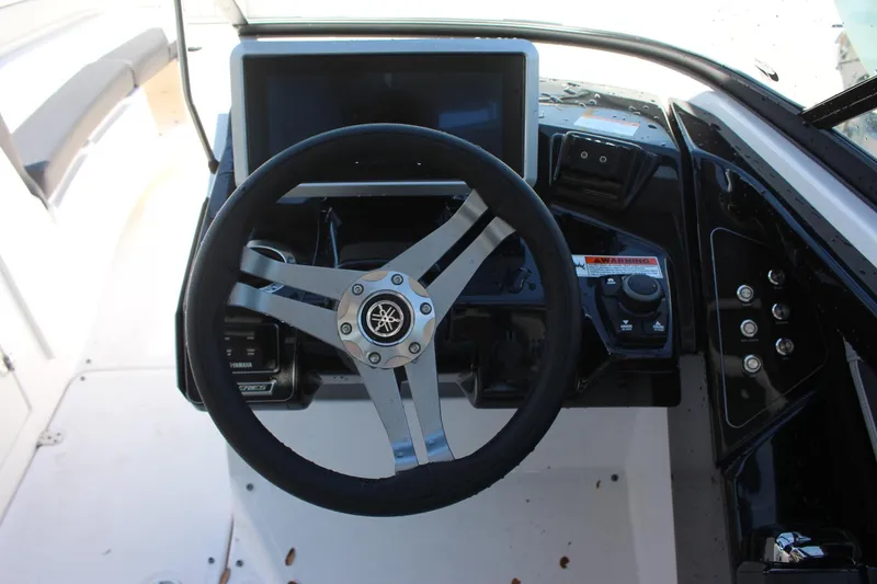 Slide: The Image of 2023 Yamaha Boats 252SE steering wheel and dashboard controls. - 9