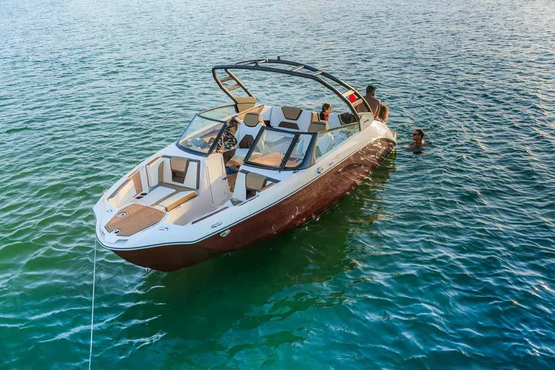 Slide: The Image of 2023 Yamaha Boats 222S on water with people swimming nearby. - 2