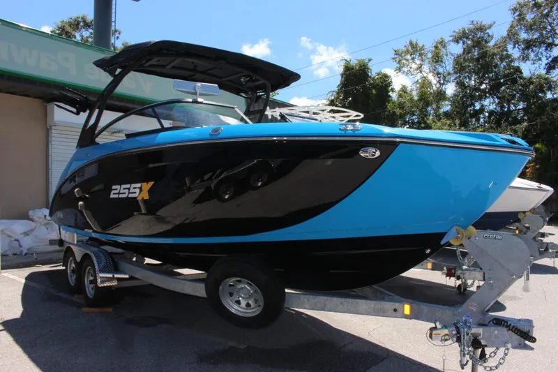 Slide: The Image of 2023 Yamaha Boats 255XE in blue and black on a trailer. - 0