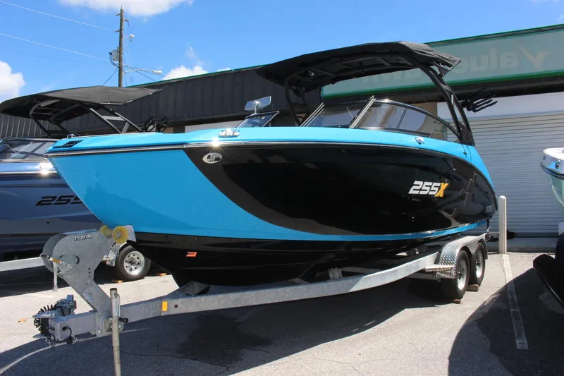 Slide: The Image of 2023 Yamaha Boats 255XE in blue and black on a trailer. - 1