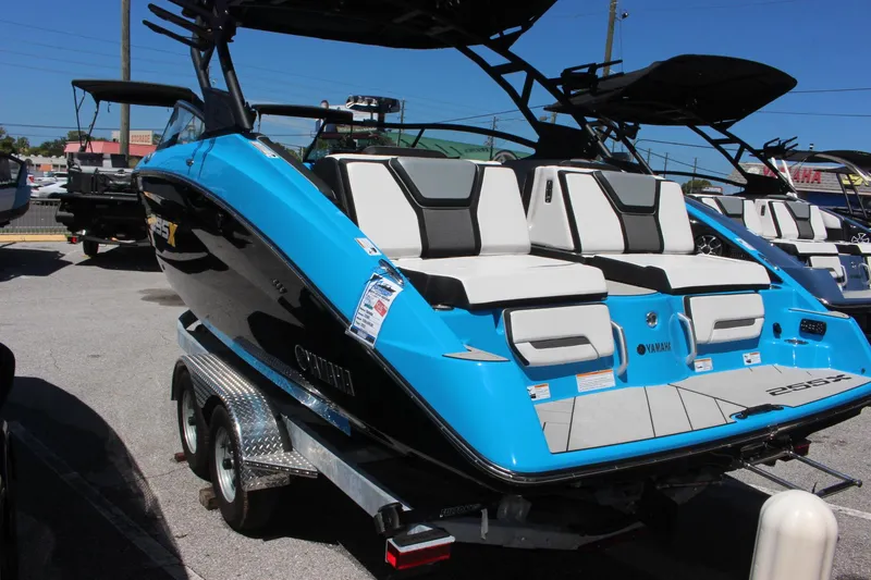 Slide: The Image of 2023 Yamaha Boats 255XE in blue and black on a trailer. - 2