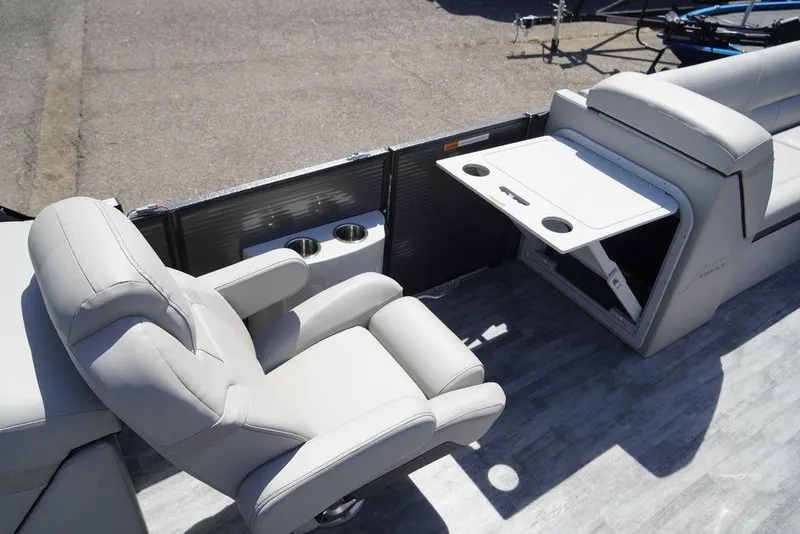 Slide: The Image of 2024 Crest Caribbean LX 250 SLC boat interior with plush seating and fold-out table. - 8