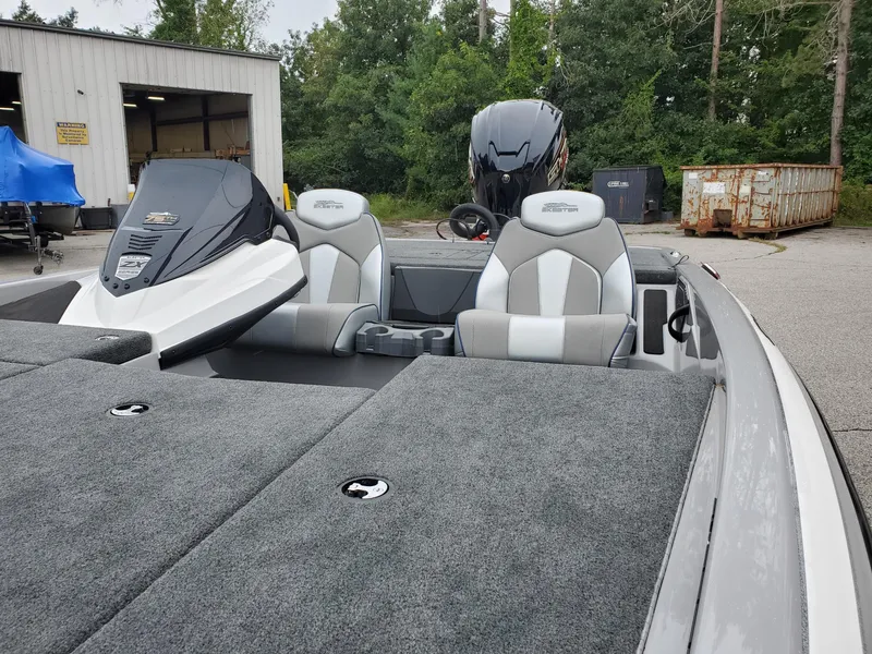 Slide: The Image of 2023 Skeeter ZX200 fishing boat with dual seats and outboard motor in a marina. - 4