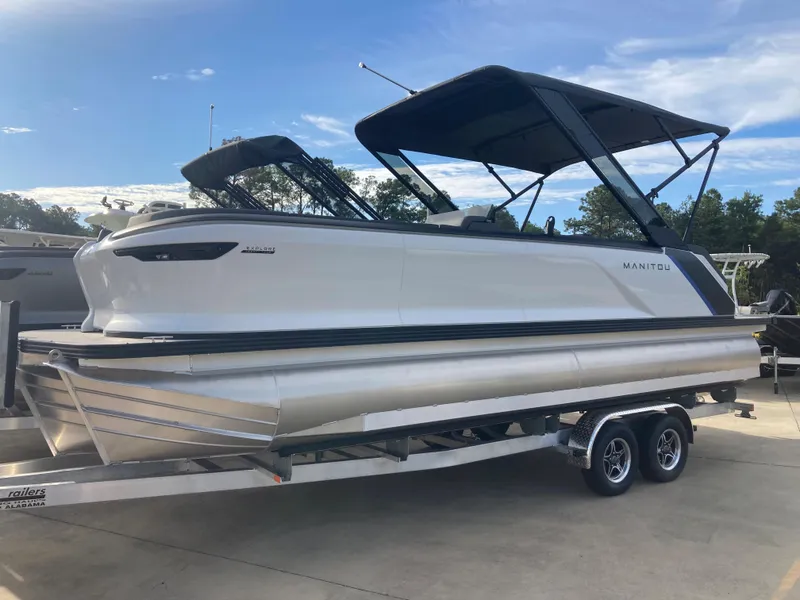 The Image of 2024 Manitou 24 EXPLORE SWITCHBACK pontoon boat on a trailer. - 1