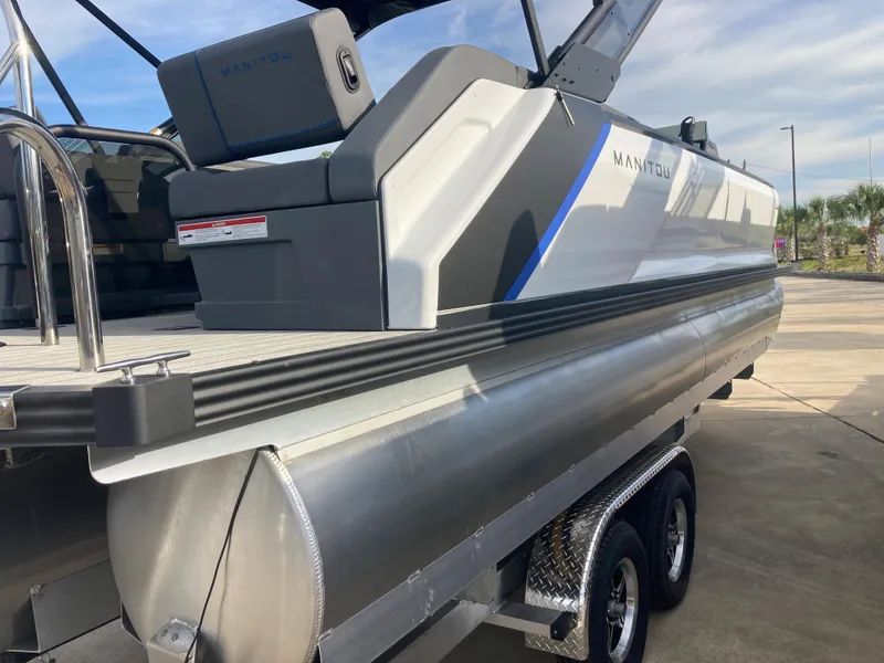 Slide: The Image of 2024 Manitou 24 EXPLORE SWITCHBACK pontoon boat on a trailer. - 19