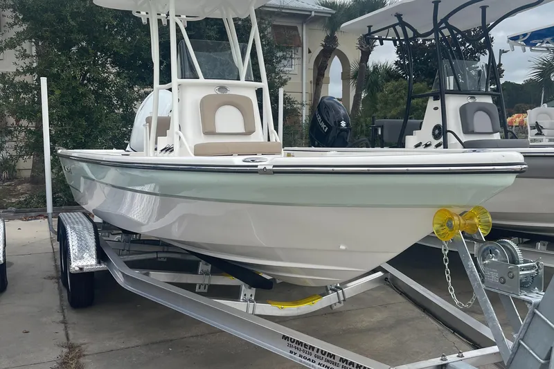 Slide: The Image of 2024 Sea Born FX21 boat on trailer, white hull, center console, outdoor display. - 2