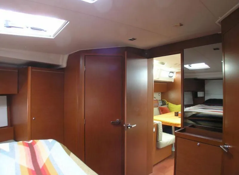 Slide: The Image of Interior of 2019 Beneteau 51.1 sailboat with wooden cabinetry and cozy seating area. - 10