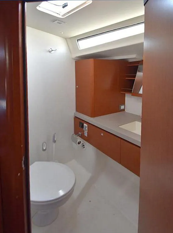 Slide: The Image of 2019 Beneteau 51.1 yacht bathroom with modern fixtures and wood cabinetry. - 13
