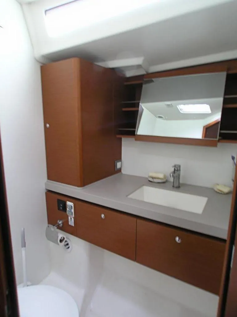 Slide: The Image of 2019 Beneteau 51.1 yacht bathroom with modern fixtures and wooden cabinetry. - 14