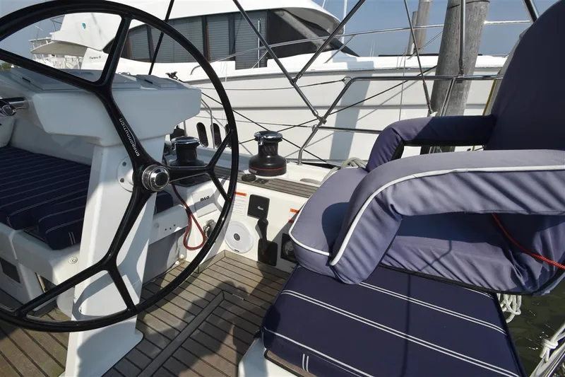 Slide: The Image of 2019 Beneteau 51.1 yacht cockpit with steering wheel and cushioned seating. - 17