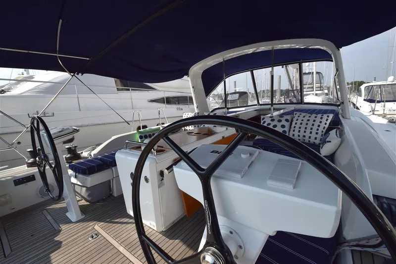 Slide: The Image of 2019 Beneteau 51.1 yacht cockpit with dual steering wheels and cushioned seating. - 24