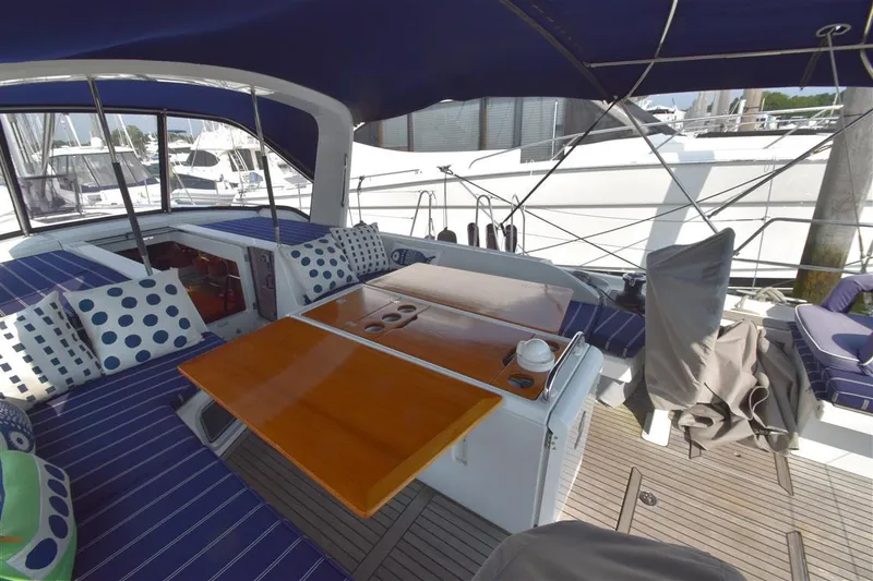 Slide: The Image of 2019 Beneteau 51.1 yacht cockpit with blue seating, wooden table, and polka dot cushions. - 29