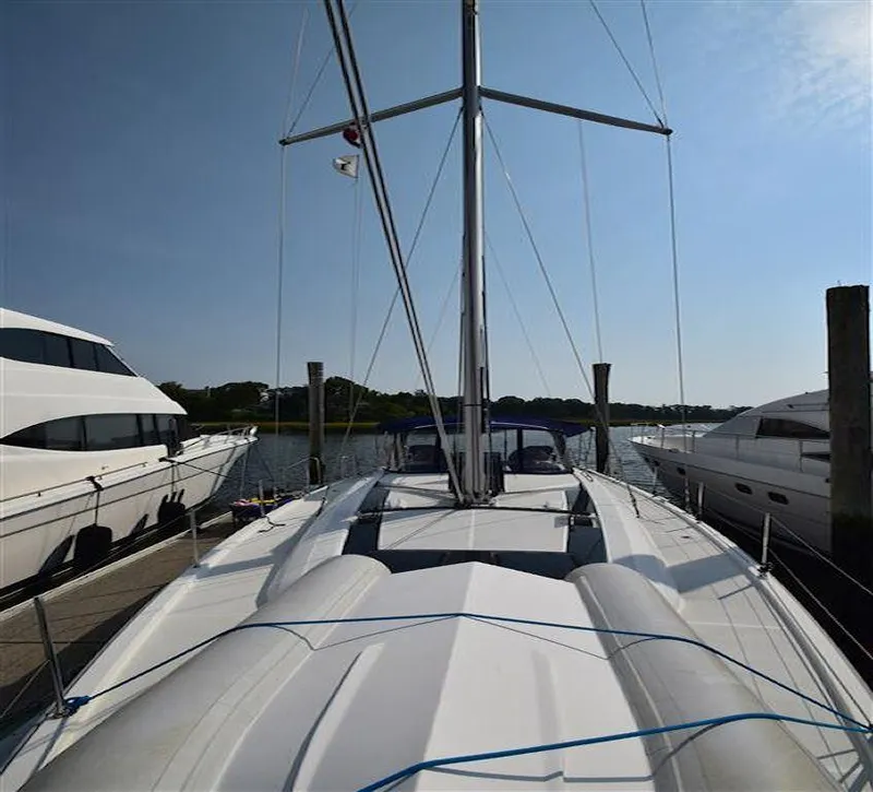 Slide: The Image of 2019 Beneteau 51.1 sailboat docked, showcasing sleek deck design and mast. - 33