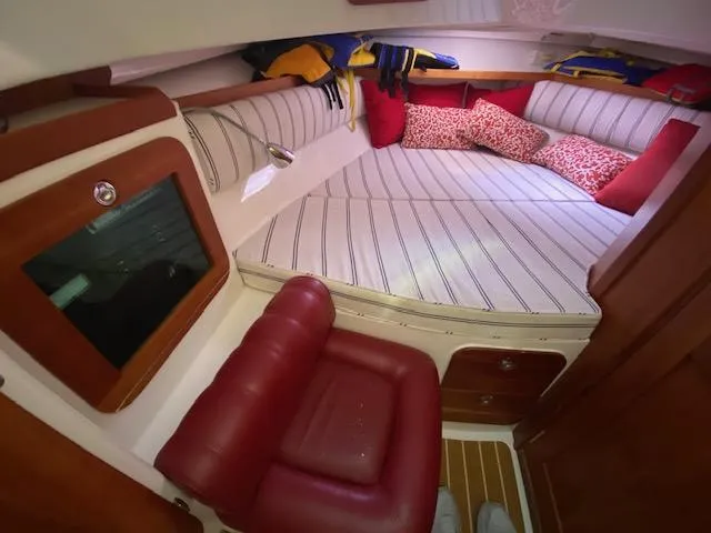 Slide: The Image of 2009 Hunt Yachts Harrier 29 cabin with striped bedding and red accents. - 10