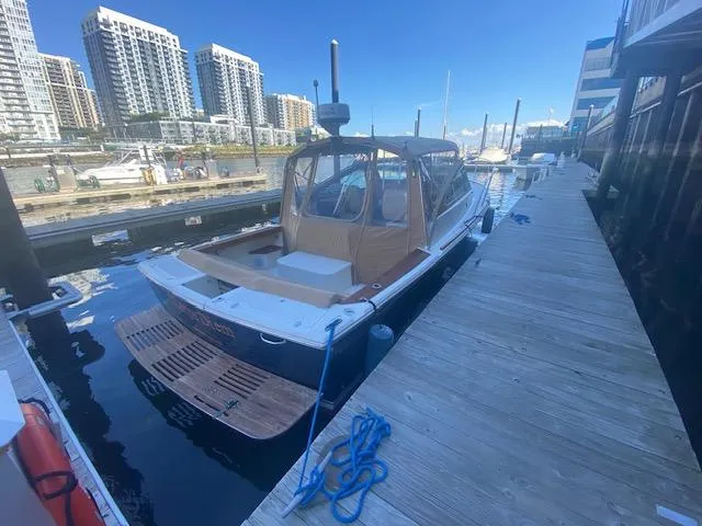 Slide: The Image of 2009 Hunt Yachts Harrier 29 docked at marina with cityscape background. - 9