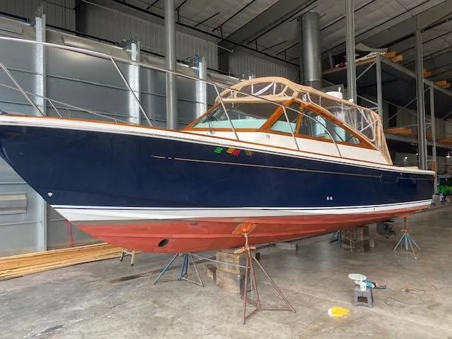 Slide: The Image of 2009 Hunt Yachts Harrier 29 in storage, blue hull, red bottom, indoor facility. - 11