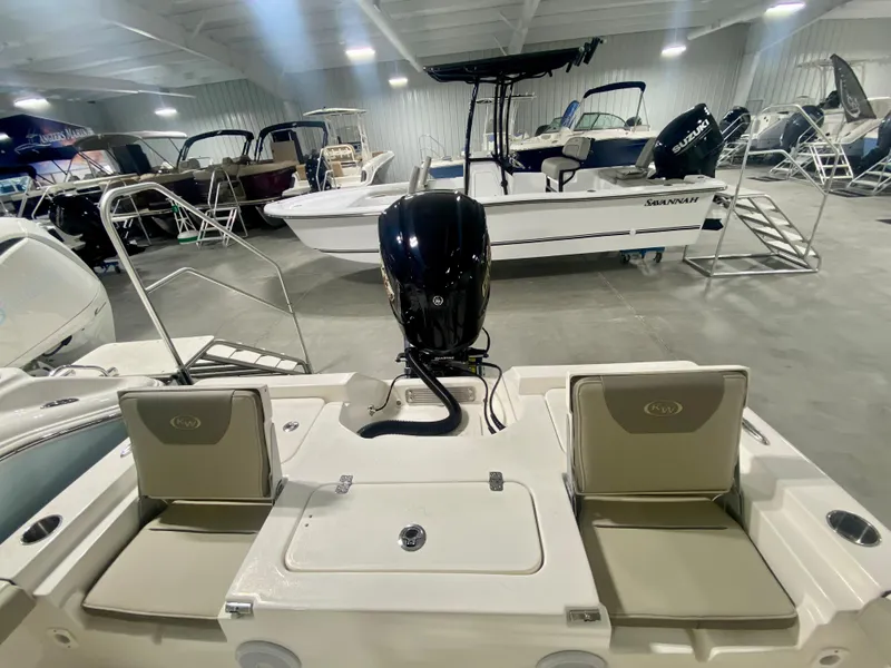 Slide: The Image of 2024 Key West 230 Bay Reef boat interior with seating and outboard motor in showroom. - 6