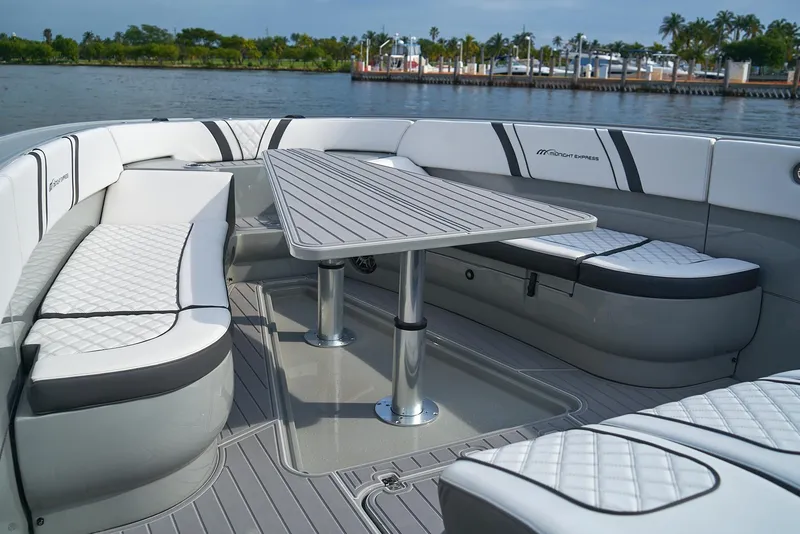 Slide: The Image of 2021 Midnight Express 43' Open boat with luxurious seating and table on the water. - 10
