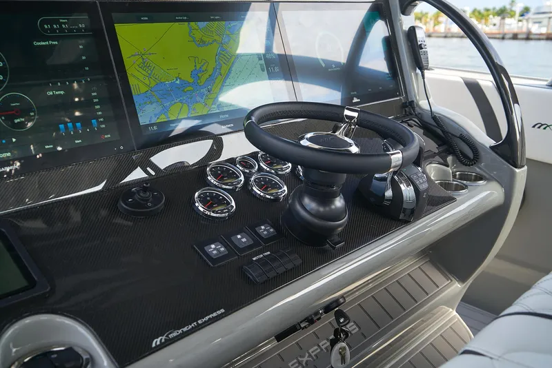 Slide: The Image of 2021 Midnight Express 43' Open boat dashboard with navigation screens and controls. - 16
