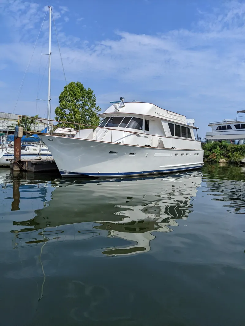 The Image of 1976 Chris-Craft Roamer yacht docked on calm water under a clear blue sky. - 0